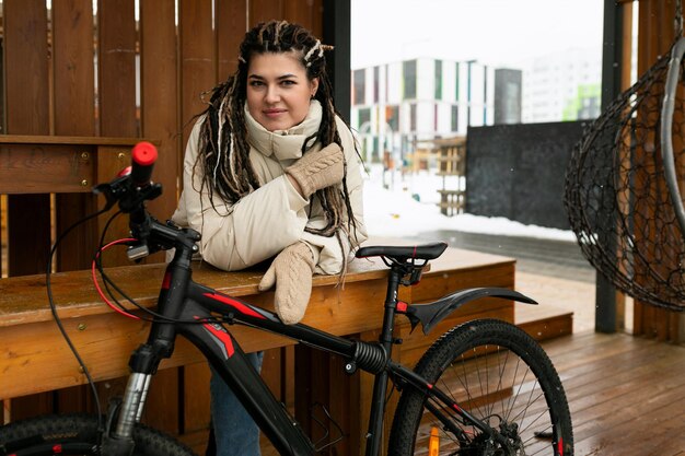 Donna seduta su una panchina accanto alla bicicletta