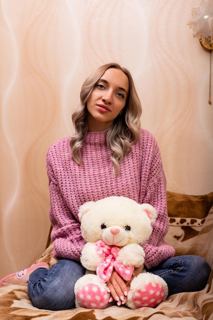 Donna seduta sul divano con un orsacchiotto Retro foto con giocattolo di peluche