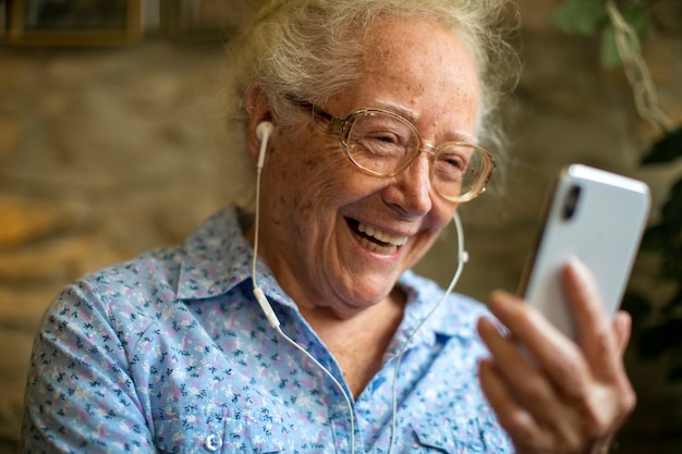 Donna senior allegra che fa una videochiamata