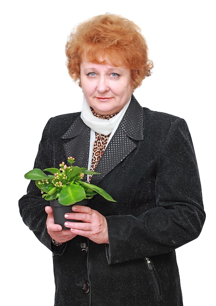 Donna senior amichevole con la pianta della casa, fiori. Isolato su bianco.