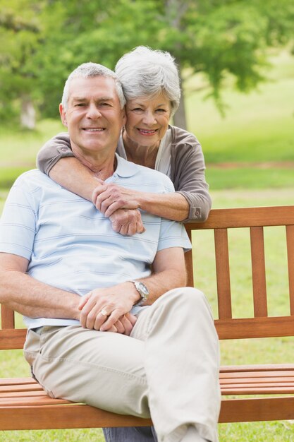 Donna senior che abbraccia uomo da dietro al parco