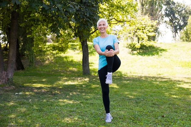 Donna senior che fa esercizio streching nel parco