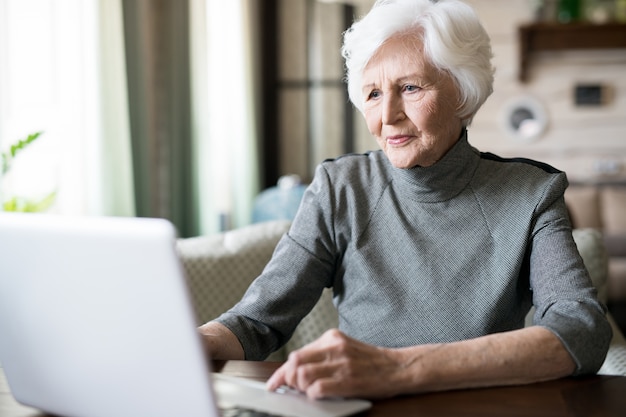 Donna senior che per mezzo di un computer portatile