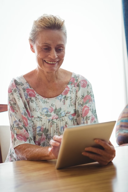 Donna senior che per mezzo di una compressa digitale