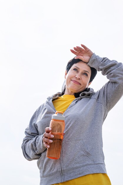 donna senior che pulisce il sudore dopo un duro allenamento all'aperto nel parco