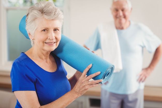 Donna senior che sorride mentre facendo i bagagli dopo l'allenamento