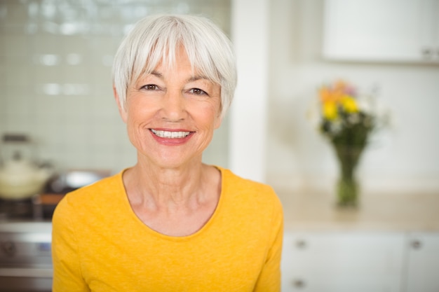 Donna senior felice in cucina