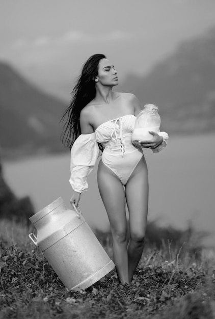 Donna sensuale con latte all'aperto alpi lattiginosi naturale latte crudo organico ragazza con una bottiglia di latte fresco