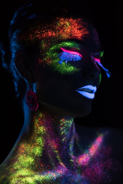 Donna sensuale nel trucco di vernice fluorescente