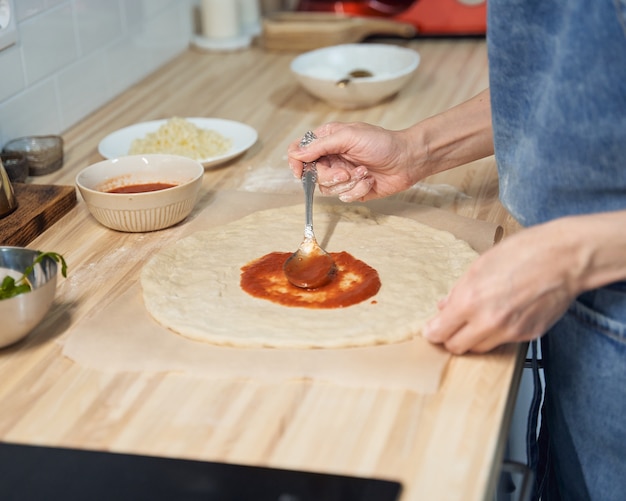 Donna senza volto topping pasta per pizza fatta in casa italiana rustica margherita. Cibo fatto in casa