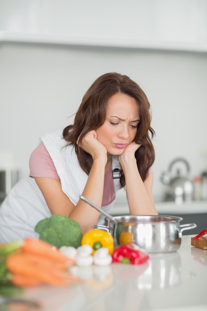 Donna seria che prepara alimento in cucina