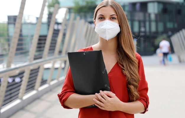 Donna seria disoccupata con la maschera protettiva che sembra preoccupata