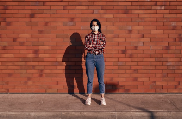 Donna seria in maschera sulla strada della città