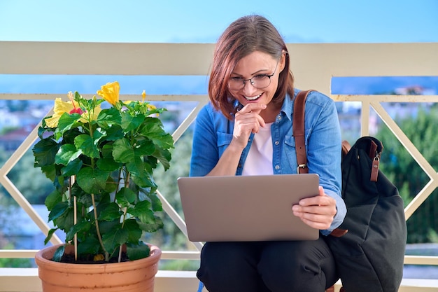 Donna seria sicura di affari maturi con il computer portatile all'aperto