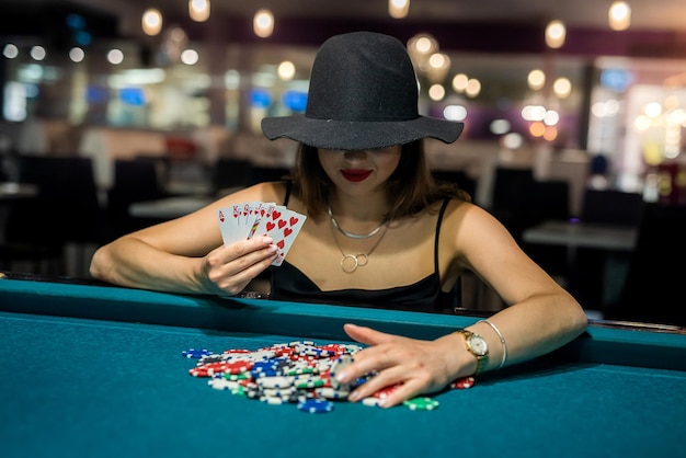 Donna sexy che gioca a poker in un elegante vestito nero al clubhouse