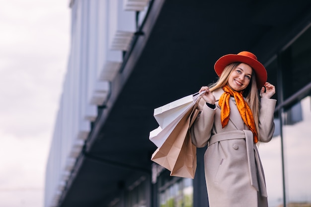 Donna shopaholic con sacchetti di carta per lo shopping passeggiate per la città