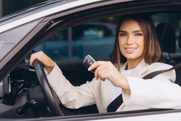 Donna sicura che tiene la chiave dell'auto all'interno di un veicolo moderno