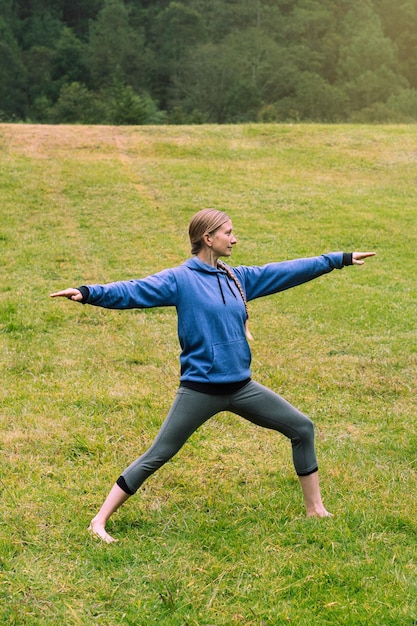 Donna sola nella foresta che si esercita, indossando abbigliamento sportivo. Salute mentale.