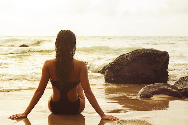 Donna sola seduta sulla spiaggia