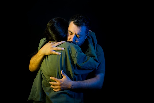 donna soldato abbraccia il marito per la guerra in uniforme militare su sfondo nero isolato