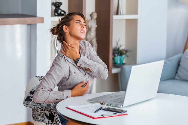 Donna sollecitata che soffre di mal di schiena dopo aver lavorato sul pc