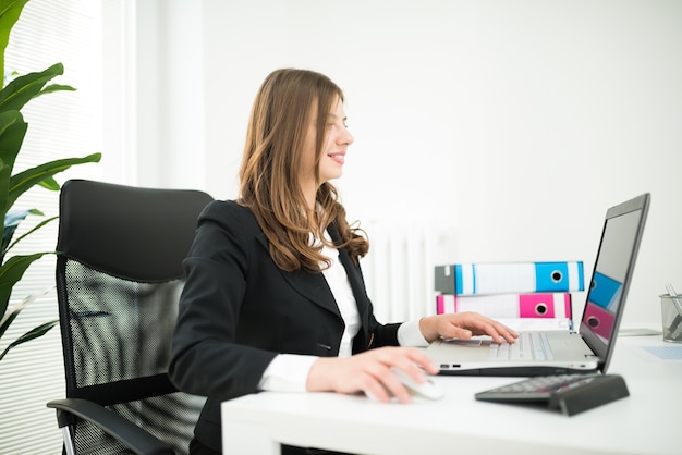 Donna sorridente al lavoro nel suo ufficio