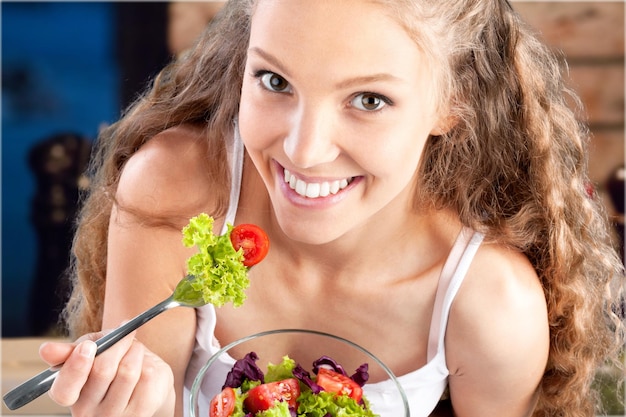 Donna sorridente caucasica attraente con insalata isolata