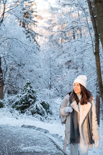 Donna sorridente che cammina nello spazio della copia del parco invernale