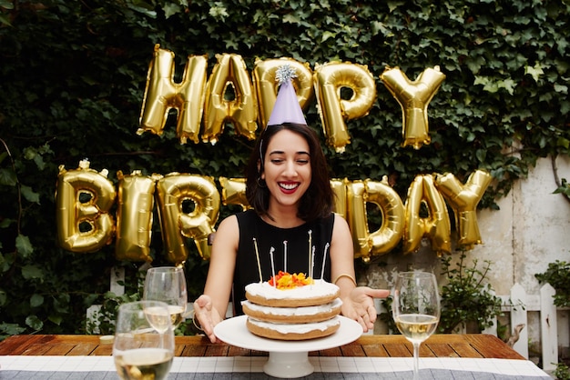 Donna sorridente che celebra il compleanno contro i palloncini