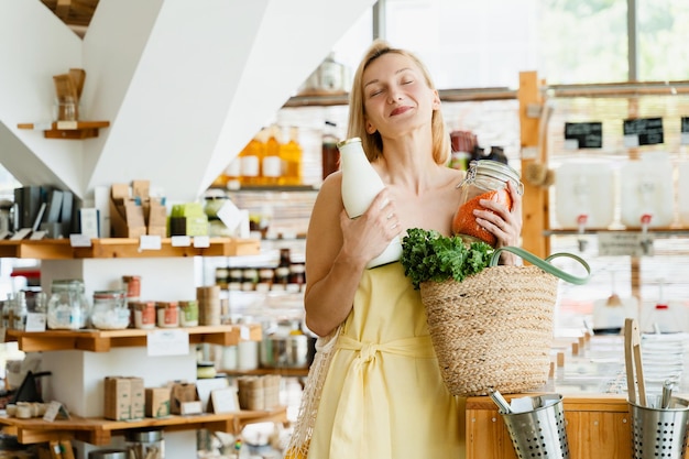 Donna sorridente che compra prodotti biologici in un negozio a rifiuti zero