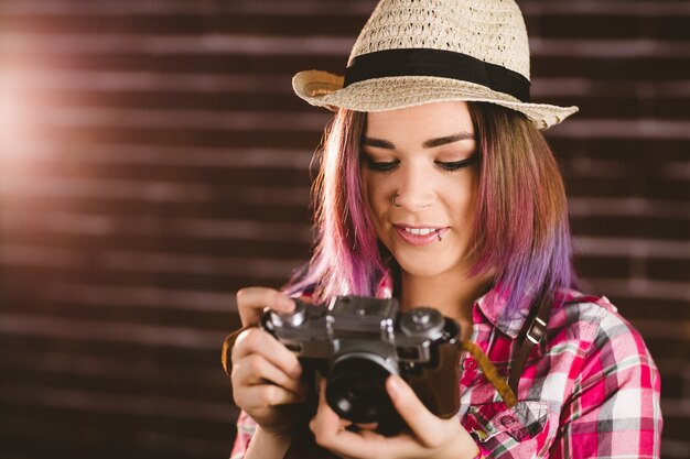 Donna sorridente che controlla le foto dalla macchina fotografica d'annata