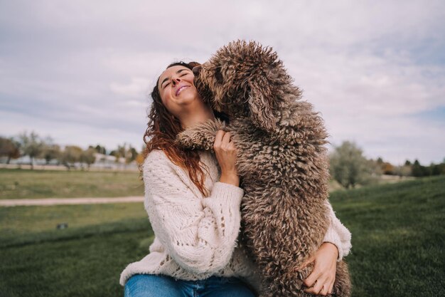 Donna sorridente che gioca con il cane