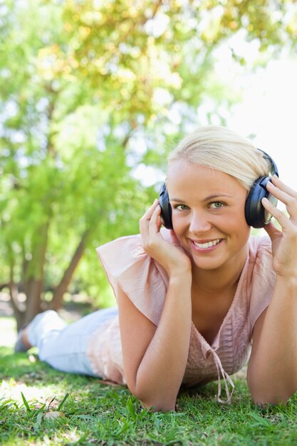 Donna sorridente che gode della musica sul prato