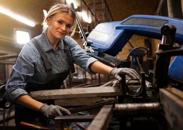 Donna sorridente che lavora in fabbrica