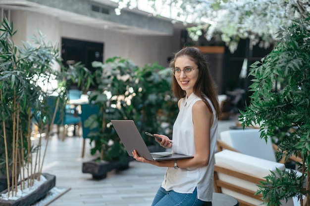 Donna sorridente che legge la sua e-mail in una caffetteria vuota