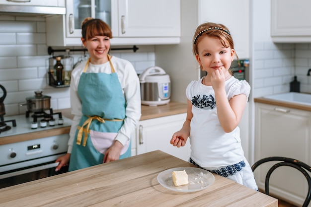 Donna sorridente che mangia le mandorle. La madre guarda sua figlia e sorride