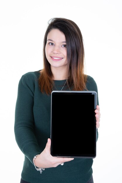 Donna sorridente che mostra lo schermo del computer della compressa nera in bianco