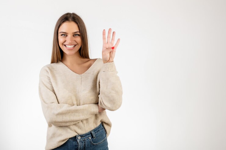 Donna sorridente che mostra quattro dita e contare isolati sopra bianco