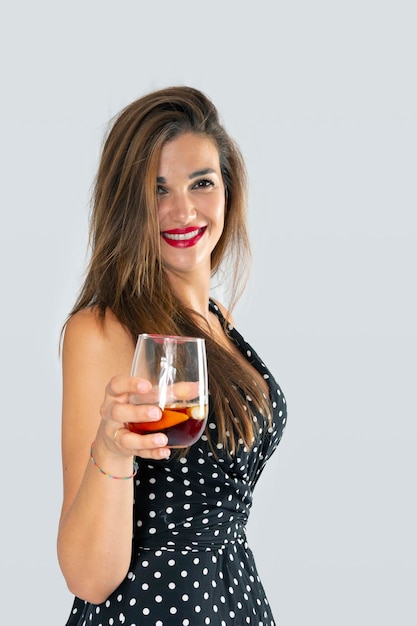 Donna sorridente che offre un bicchiere di vino per un brindisi