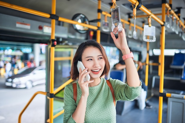 Donna sorridente che parla al telefono in autobus