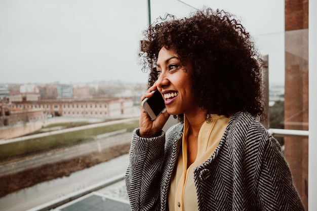 Donna sorridente che parla al telefono in città