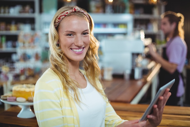 Donna sorridente che per mezzo della compressa digitale