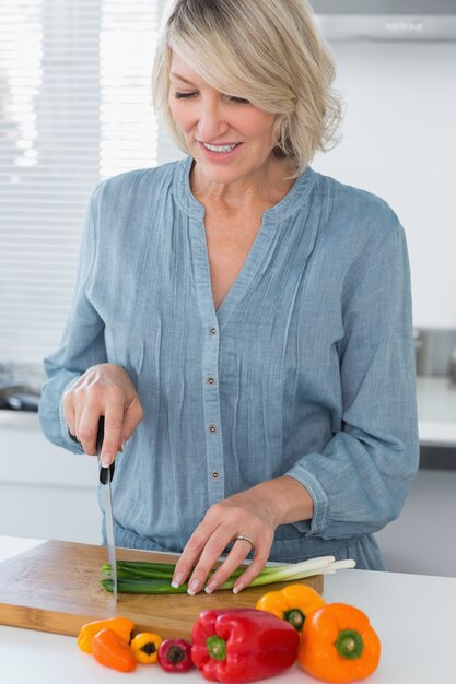 Donna sorridente che prepara le verdure