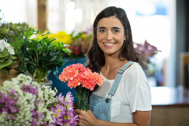 Donna sorridente che seleziona i fiori al negozio di fiorista