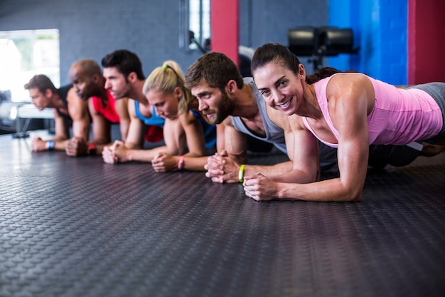 donna sorridente che si esercita con gli amici in palestra