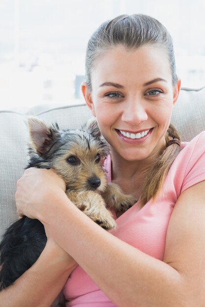 Donna sorridente che stringe a sé il suo Yorkshire terrier sullo strato