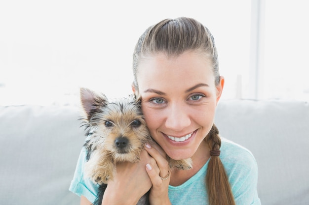 Donna sorridente che tiene il suo cucciolo dell&#39;Yorkshire terrier