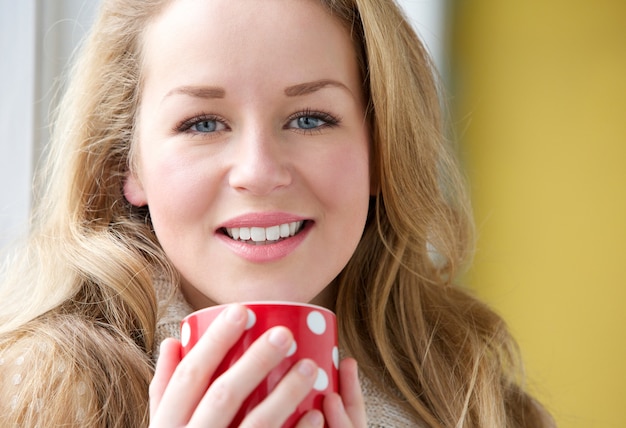 Donna sorridente che tiene tazza di tè