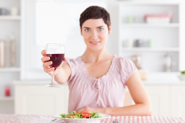 Donna sorridente che tosta con il vino