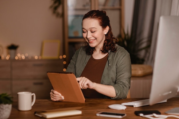 Donna sorridente che utilizza il suo tablet a casa